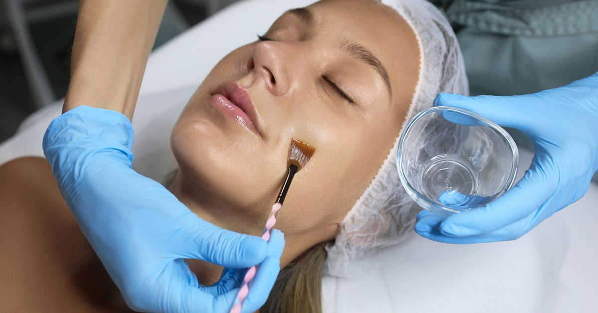 A woman receiving a beneficial facial treatment at a beauty salon, which includes chemical peels.