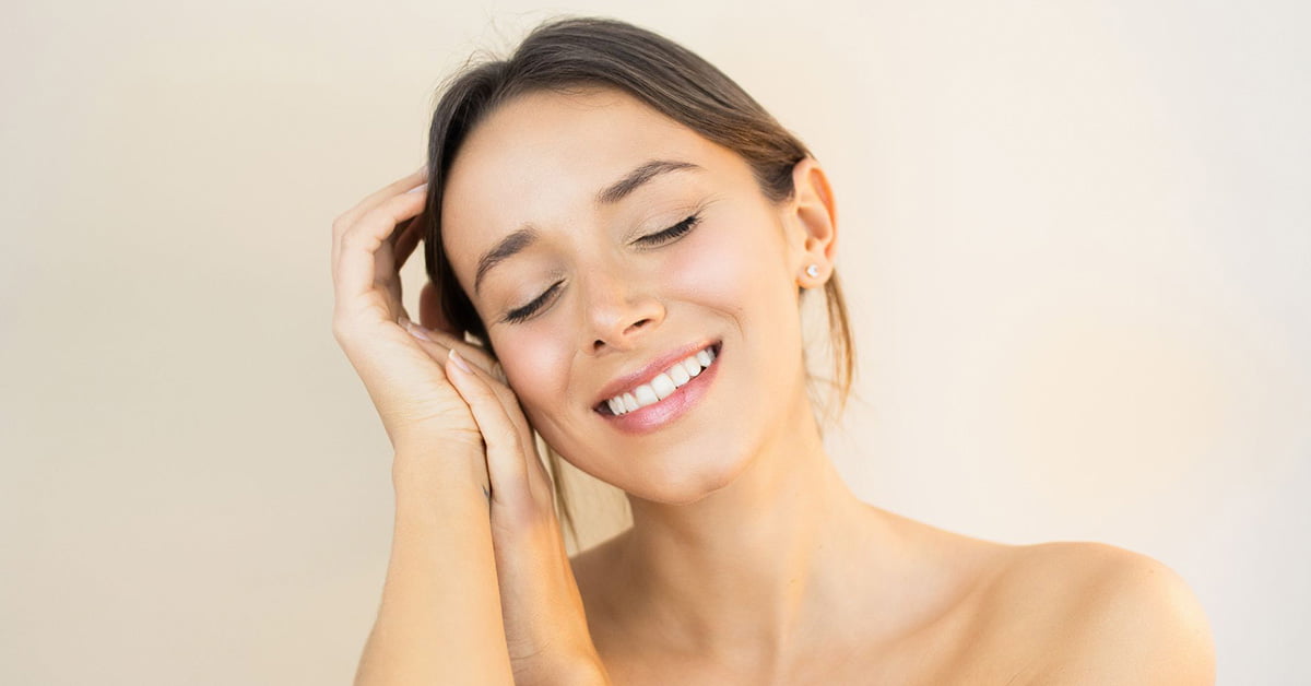 A young woman smiling with her hands on her face, experiencing the VR-Shot.