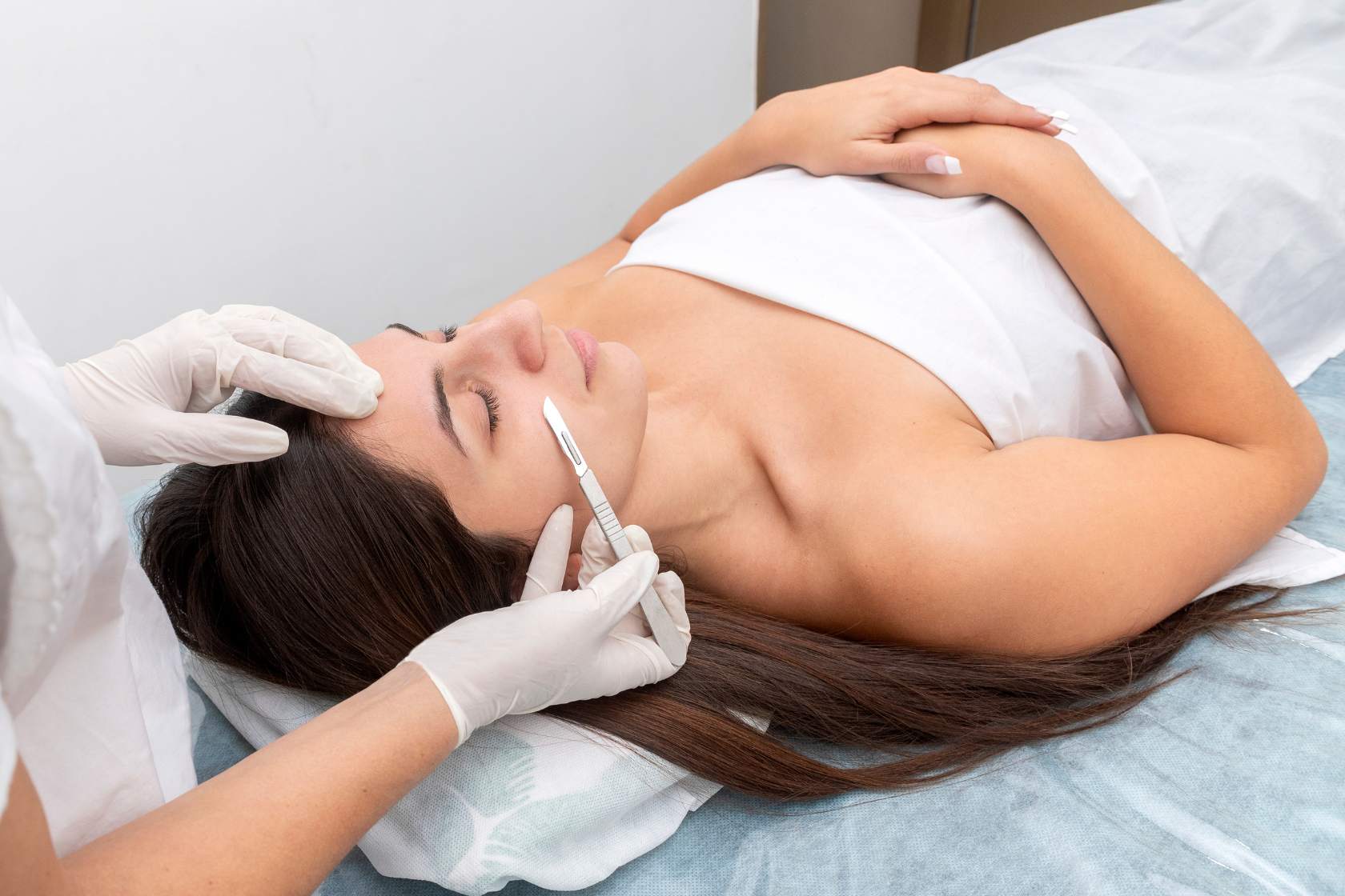 A woman receiving dermaplaning treatments at a beauty salon.