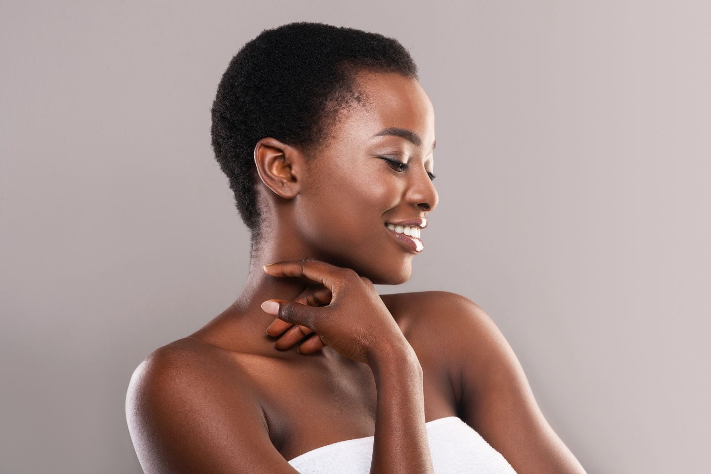 A young black woman smiling with her hand on her chin.