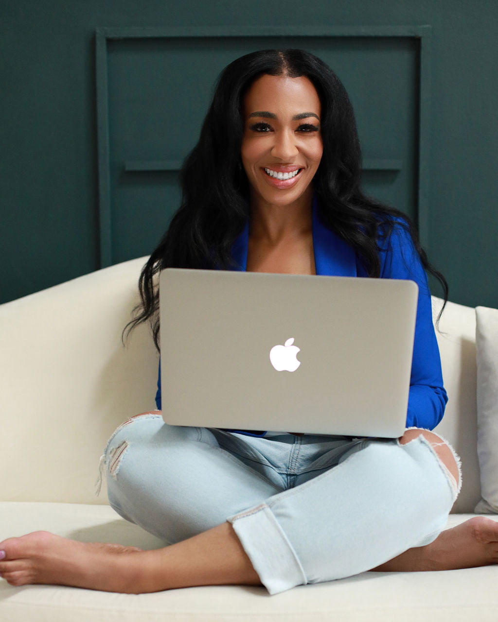 A woman sitting on a couch with a laptop while meeting with Dr. Scott.