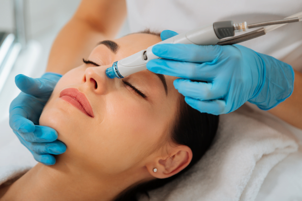 A woman experiencing hydrafacial treatment at a beauty spa.