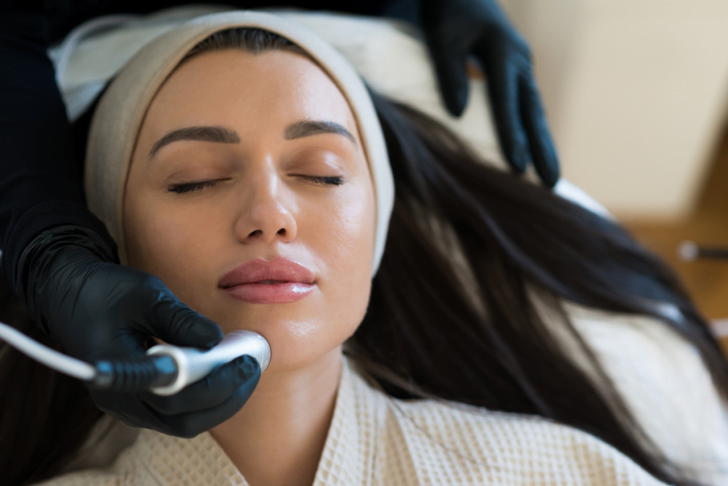 A woman experiencing the benefits of a hydrafacial treatment at a beauty salon.