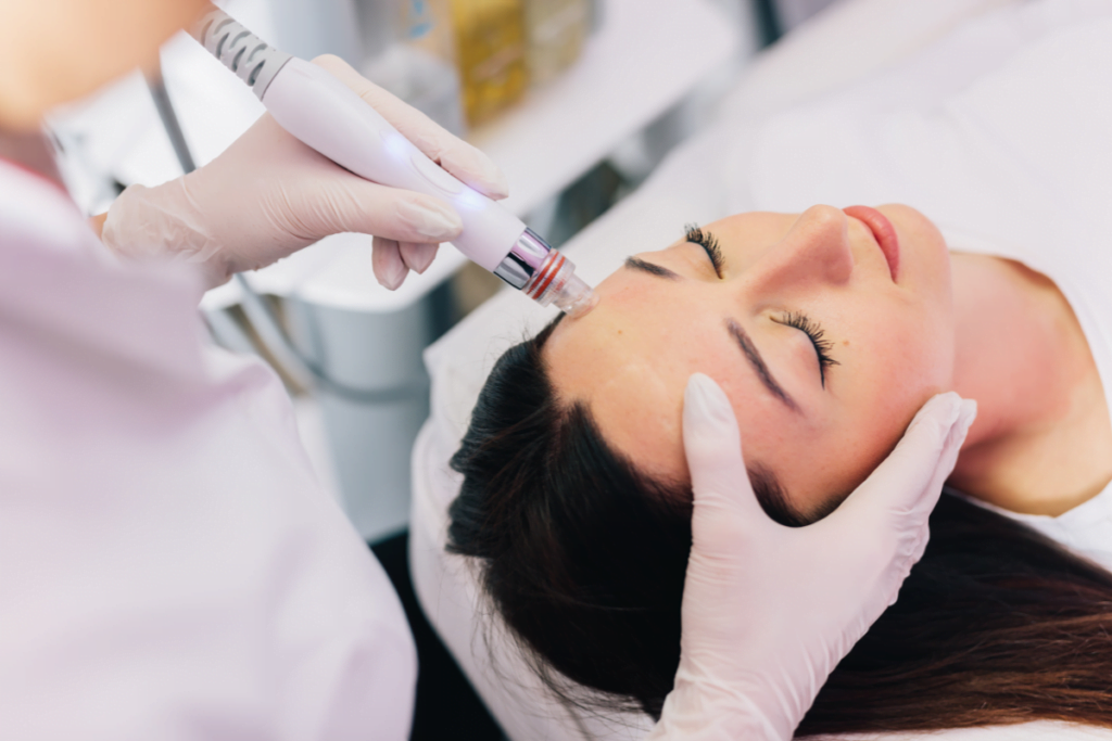 A woman receiving hydrafacial treatment at a beauty clinic.