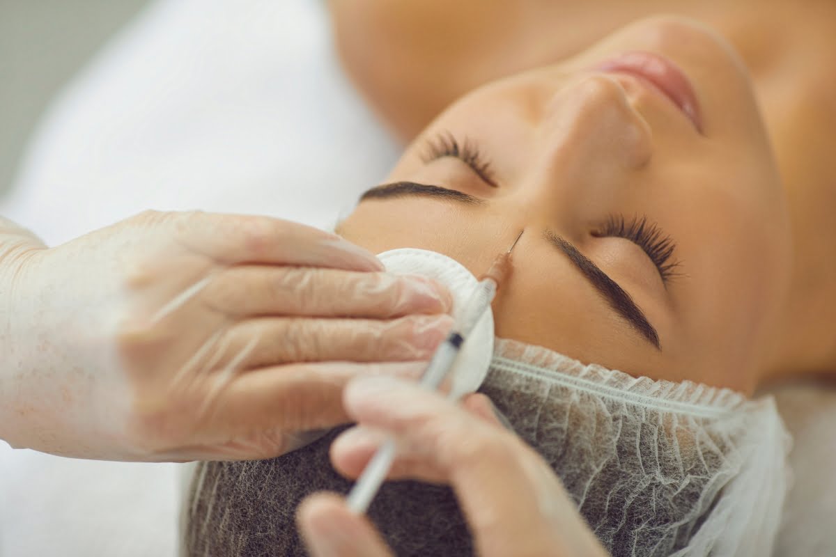 A person receiving a professional facial treatment, focusing on their nose area, experiences the benefits of neurotoxin treatments.