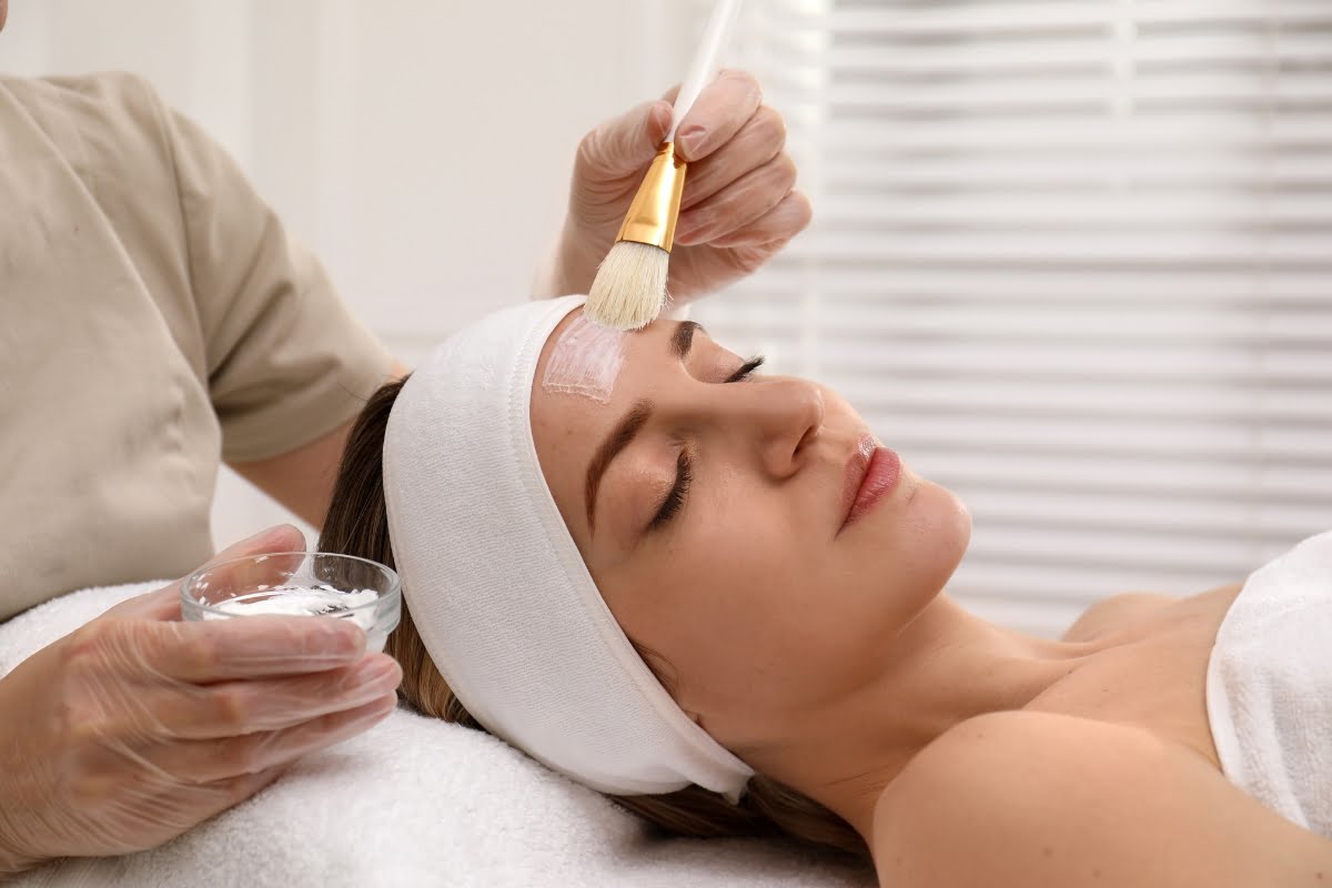 Woman receiving physical exfoliation with a brush in a spa setting.