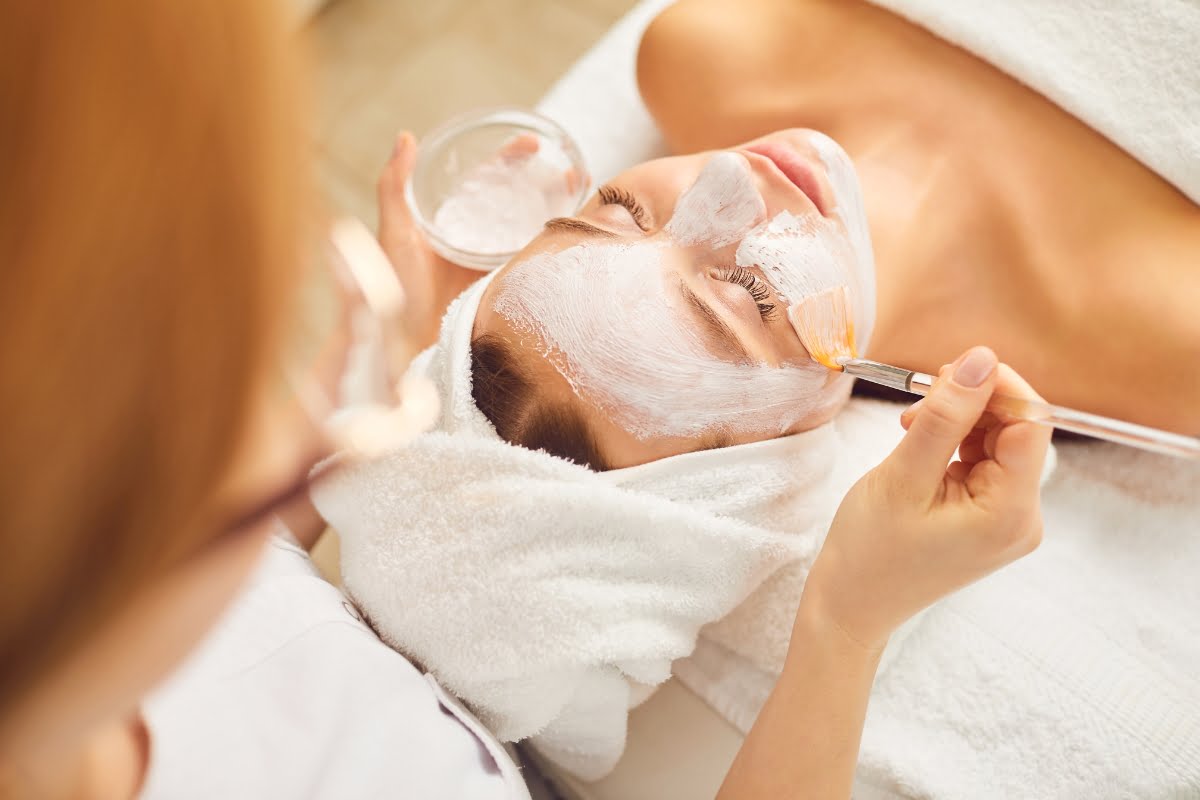 A woman receiving a physical exfoliation treatment with a brush in a spa.