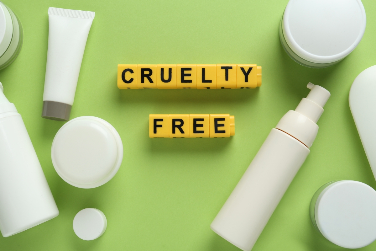 Sustainable skincare and cosmetic product containers are arranged around yellow blocks bearing the words "CRUELTY FREE" on a green background.